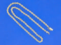 Gold rope chain necklace on a blue background